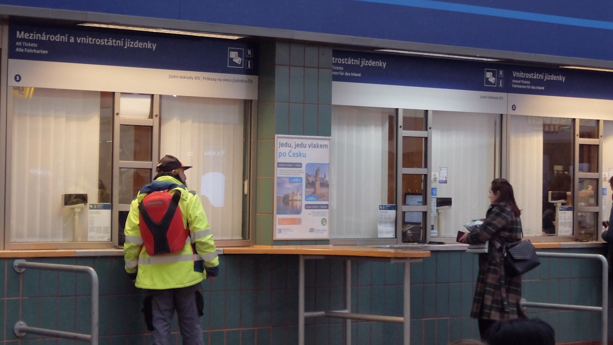 People at a train station ticket counter